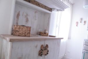 a white room with a wooden shelf and a window at Laguna Suite B&B in Chioggia