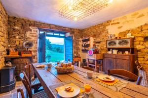 a dining room with a wooden table and a large window at B&B Cascina Sant'Elena in Bubbio