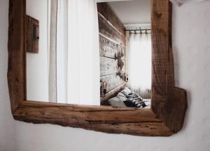 a mirror with a wooden frame hanging on a wall at Laguna Suite B&B in Chioggia
