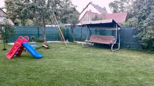 a backyard with a swing set and a hammock at Ubytovanie Taraj in Zuberec