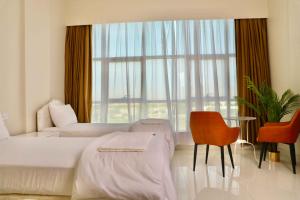 a hotel room with a bed and a large window at Sur Inn Hotel Apartments صور ان للشقق الفندقية in Sur