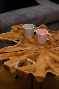 zwei Kaffeetassen auf einem Holztisch in der Unterkunft Apartments City Center Grzybowska by Renters Prestige in Warschau