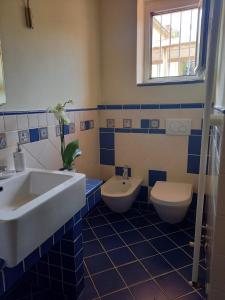 een badkamer met een wastafel en 2 toiletten bij Appartamento F&M in Castelnuovo Magra
