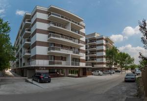 un grand immeuble d'appartements avec des voitures garées dans un parking dans l'établissement Park Residence 5, 2 Bedroom Apartment, à Bucarest