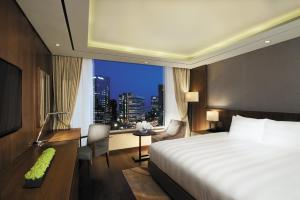 a hotel room with a bed and a desk and a window at LOTTE City Hotel Mapo in Seoul