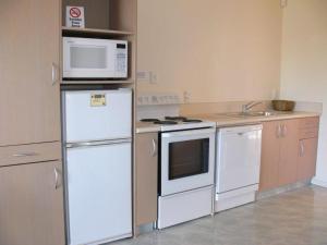 a kitchen with a white refrigerator and a microwave at Valdez Motor Lodge in Hastings