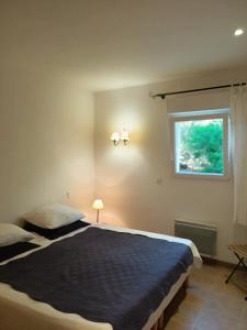 a bedroom with a bed and a window at Charmante Petite Maison & Terrasse Plein SUD au Calme ! in Entrecasteaux