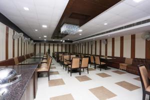 un ristorante con sedie e tavoli in una stanza di Collection O Haridwar Railway Station Formerly Le Central a Haridwār