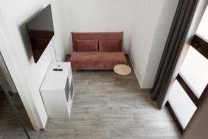 Habitación pequeña con sofá y mesa. en Lofty loft - Chiese en Milán