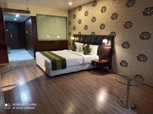 a hotel room with a bed and a projection screen at Hotel Patliputra Exotica in Patna