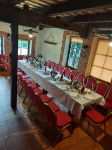 a long table in a room with red chairs at Vasilevičių Sodyba - Entire Homestead with Sauna in Piauliai