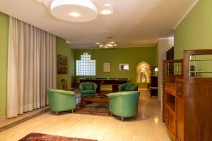 sala de estar con paredes verdes, mesa y sillas en Hotel Villa dei Pini, en San Terenziano