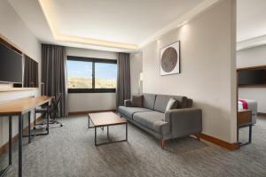 a living room with a couch and a table at Ramada by Wyndham Izmir Aliaga in İzmir