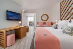 a hotel room with two beds and a television at Aqua Natura Bay in Porto Moniz