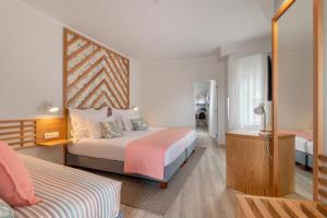 a hotel room with two beds and a mirror at Aqua Natura Bay in Porto Moniz
