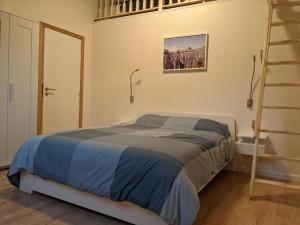 1 dormitorio con cama y escalera en Les Récollets, en Huy
