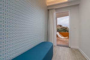 a room with a blue couch and a window at Aqua Natura Bay in Porto Moniz