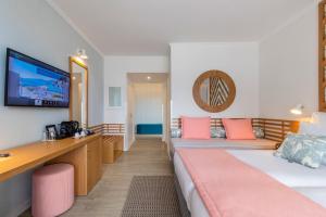 a hotel room with two beds and a flat screen tv at Aqua Natura Bay in Porto Moniz
