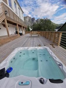 a hot tub on the deck of a house at Waterfront Senja 2 in Torsken