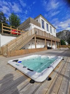 a hot tub on a deck in front of a house at Waterfront Senja 2 in Torsken