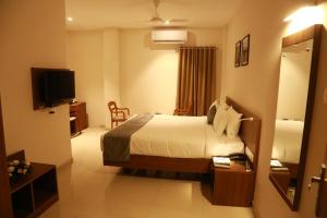 a hotel room with a bed and a television at Hotel Picnic in Manjeri