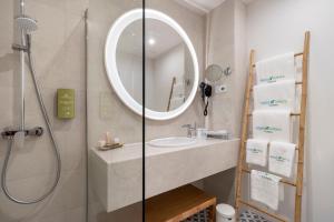 a bathroom with a sink and a shower with a mirror at Aqua Natura Bay in Porto Moniz