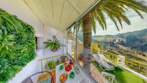 a balcony with a table and a palm tree at Sweet Home Masca in Masca