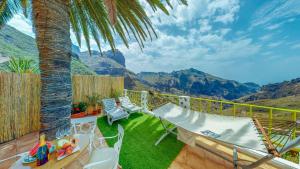 een patio met een hangmat en uitzicht op de bergen bij Sweet Home Masca in Masca