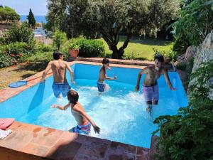 a group of men playing in a swimming pool at Medieval tower & villa by the sea in Caldes d'Estrac
