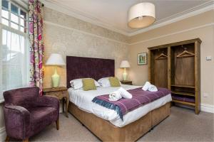 a bedroom with a large bed and a chair at Inn in the Park in Bournemouth