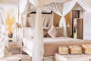 a bedroom with a white bed with a canopy at Khwan Beach Resort - Luxury Glamping and Pool Villas Samui - Adults Only - SHA Extra Plus in Mae Nam