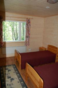 1 dormitorio con cama y ventana en Lomasaaret Cottages, en Villala