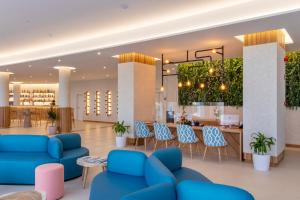 a lobby with blue couches and a bar at Aqua Natura Bay in Porto Moniz