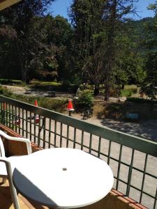 d'une table et de chaises blanches sur un balcon. dans l'établissement Hotel Le Mas Fleuri, à Vernet-les-Bains