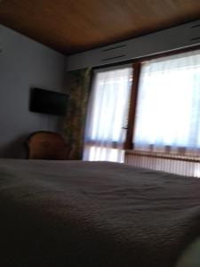 sypialnia z łóżkiem i oknem w obiekcie Hotel Le Mas Fleuri w mieście Vernet-les-Bains