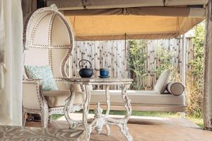 a table and a chair in front of a window at Khwan Beach Resort - Luxury Glamping and Pool Villas Samui - Adults Only - SHA Extra Plus in Mae Nam