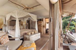 a hotel room with a bed and a canopy at Khwan Beach Resort - Luxury Glamping and Pool Villas Samui - Adults Only - SHA Extra Plus in Mae Nam