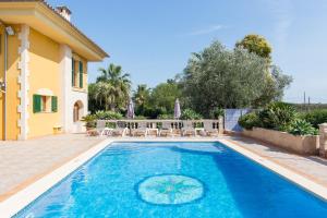 a swimming pool with chairs and a house at Villa Son Ferragut in Sa Pobla