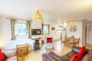 a living room with a couch and a table at Heather Lodge 4, sleeping 6 in Belladrum