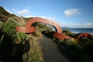 um banco sentado ao lado de uma praia em South Sea Hotel - Stewart Island em Half-moon Bay