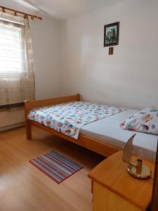 Dormitorio pequeño con cama y mesa en Apartman Nardi, en Vir