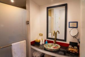 W łazience znajduje się umywalka i lustro. w obiekcie The Belle Rive Boutique Hotel w mieście Luang Prabang