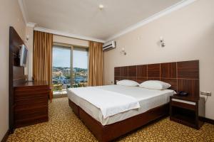 a hotel room with a bed and a television at SUENA HOTEL Çeşme in Çeşme