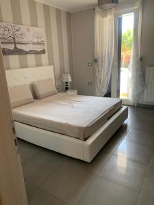 1 cama blanca en un dormitorio con ventana en house231 en Manduria