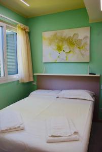a bedroom with a white bed with a green wall at Appartamento Roero cottage 3 in Alba