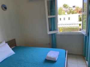 a bedroom with a blue bed and a window at Vitamin Sea Protaras in Protaras
