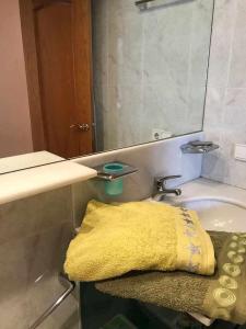 a yellow towel sitting on a bench next to a sink at Centro, luz y tranquilidad Duquesa brisas de vino in Logroño