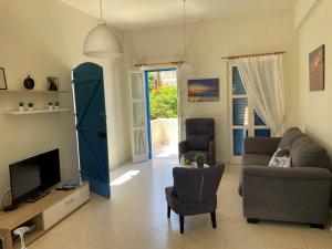 a living room with a couch and a tv at Vitamin Sea Protaras in Protaras