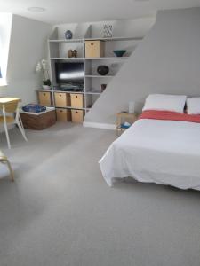 a white bedroom with a bed and a table at Sandra & Andrew's B&B in London
