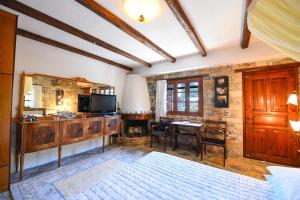 a bedroom with a television and a table in a room at Mountainescape- sale in Khalkiás